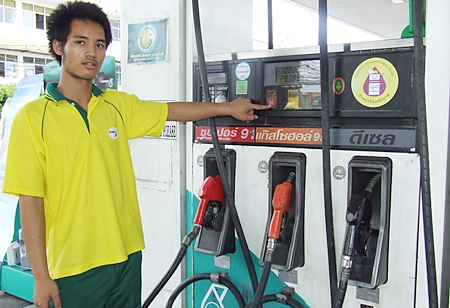 Pathawee Duakhanad, a Petronas pump employee, shows how cheap petrol has become.